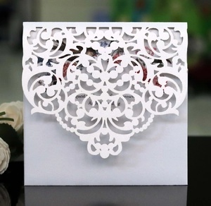 Detailed macro view of laser-cut white floral lace invitation and interior card details