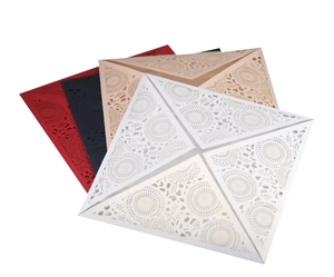 Macro detail of laser-cut wedding invitation covers in red, blue, beige, and white colors