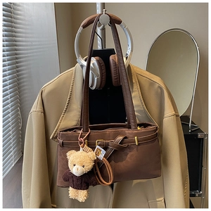 Close-up of vintage brown leopard shoulder bag with a cute teddy bear plush charm