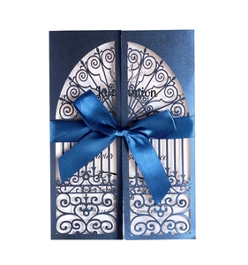 Détail de l'invitation découpée au laser bleu marine avec nœud en satin et texture nacrée