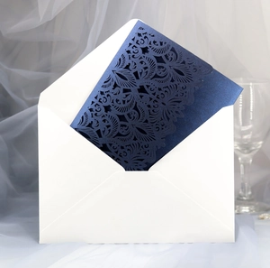 Macro view of dark blue lace laser-cut wedding invitation with elegant hollow pattern