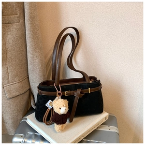 Detail view of vintage leopard pattern bucket bag with teddy bear charm and brown leather straps