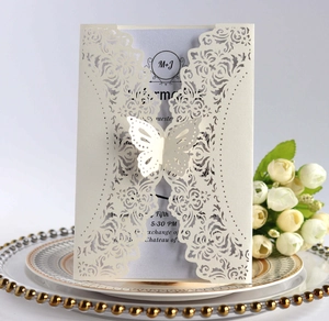 Intricate laser-cut floral wedding invitation with a 3D butterfly and blue insert card