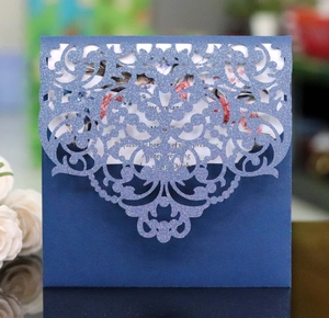 Close-up of laser-cut lace pattern on navy blue glitter paper wedding invitation card