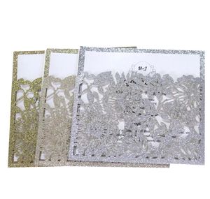 Detailed laser-cut floral pattern and glitter finish on elegant wedding invitations