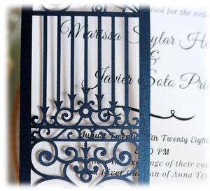 Close-up of laser-cut dark blue wedding invitation featuring pearlescent floral hollow patterns