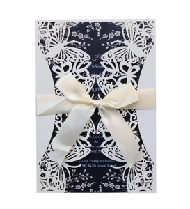 Laser cut white butterfly wedding invitation with navy blue insert and cream ribbon bow