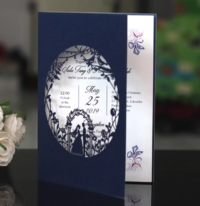 Detail of navy blue laser-cut wedding invitation featuring elegant silhouette and white insert