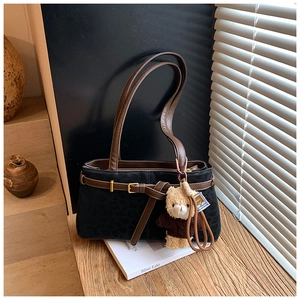 Detail of vintage leopard print suede bucket bag with leather strap and teddy charm
