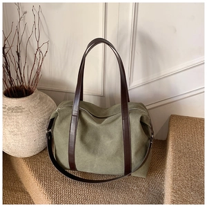 Dettaglio della borsa tote in tela verde oliva con cinturini in pelle marrone scuro
