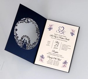 Detailed laser-cut navy wedding invitation with elegant white insert and floral prints