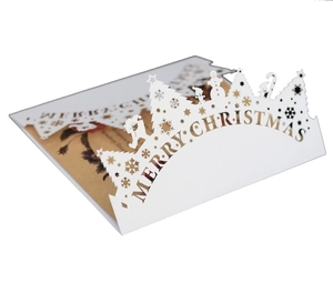 Detail of laser-cut Merry Christmas card showing intricate snowflake and tree patterns