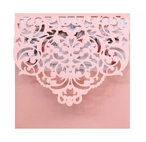 Pink laser-cut pearlescent wedding invitation with ornate floral scrollwork and inner card