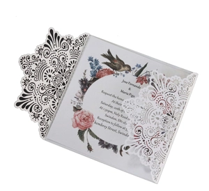 Détail d'invitation de mariage découpée au laser avec motifs dentelle et carte florale
