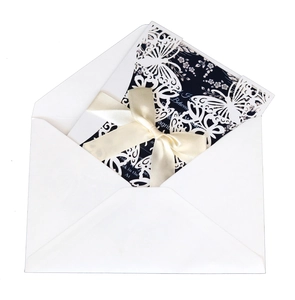 Elegant laser-cut butterfly wedding invitation set with cream bow and floral liner