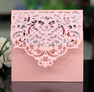 Detail of pink laser-cut lace invitation card with pearlescent finish and floral insert