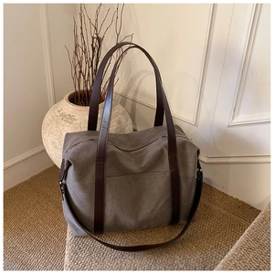 Close-up of canvas tote bag texture with leather straps and exterior pocket detail
