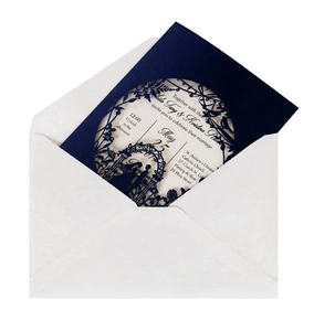 Detailed laser-cut floral patterns on navy blue wedding invitation cover and white inner card