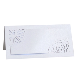 Macro detail of white laser-cut floral wedding place card with pearlescent texture