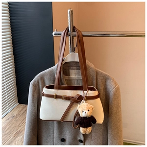 Detail shot of vintage bucket bag with decorative buckle and plush bear charm