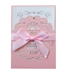 Pink laser-cut wedding invitation with lace patterns, ribbon bow and white insert card