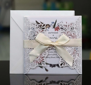 Détail d'invitation de mariage découpée au laser avec un ruban de soie élégant