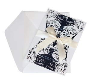 Laser-cut butterfly invitation set with navy blue card, white cover, and satin ribbon bow