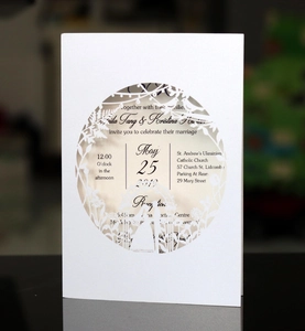 Detail of laser-cut white wedding invitation with elegant circular patterns and black text