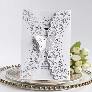 Elegant laser-cut wedding invitation with rose patterns and 3D butterfly on a ceramic plate