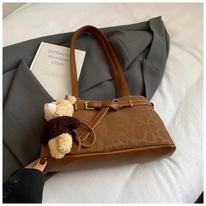 Brown leopard-style bucket bag with a decorative metal buckle and cute bear pendant
