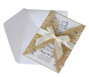 Elegant gold laser cut wedding invitation with white ribbon and matching envelope