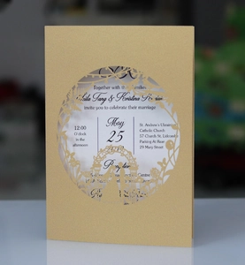 Detail of laser-cut wedding invitation with champagne gold glitter and floral arch
