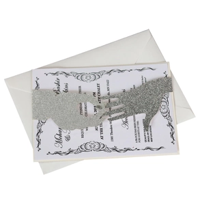 Macro detail of laser-cut glitter silver sleeve and white wedding invitation card set