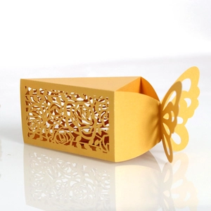 Detail of laser-cut gold wedding favor box featuring rose patterns and butterfly top