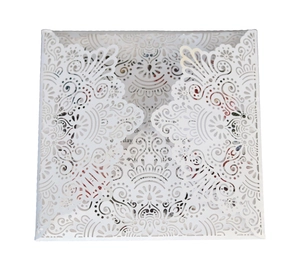 Elegant white laser-cut wedding invitation with intricate floral hollowed patterns