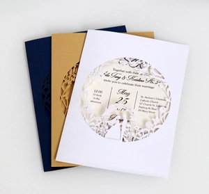 Detail of laser cut wedding invitations in white and gold with floral hollow patterns