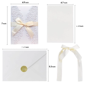 White laser-cut wedding invitation set with ribbon bow and gold seal stickers