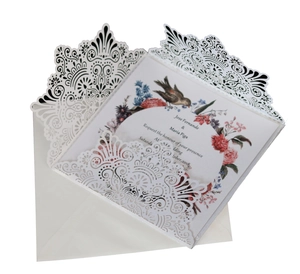 Detail of laser-cut wedding invitation showing intricate floral hollow sleeve and inserts