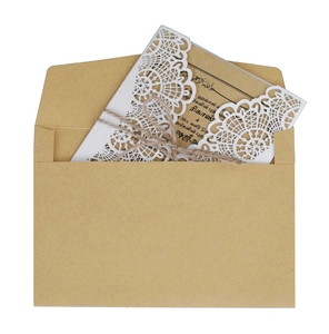 Laser-cut floral wedding invitation set with kraft envelope and twine bow on white background