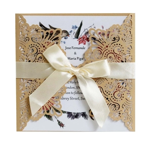 Détail de l'invitation de mariage découpée au laser avec insert fleuri et nœud satiné