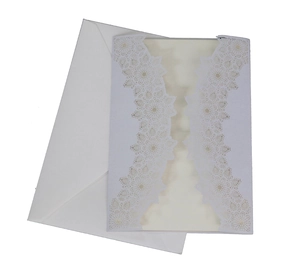 Macro shot of white laser-cut floral lace wedding invitation with insert card and envelope