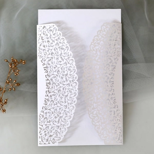 Detailed laser-cut vine patterns on elegant white wedding invitation with floral lace