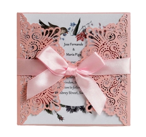 Détail d'invitation de mariage rose découpée au laser avec motif arabesque et ruban