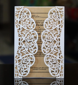 Laserschnitt-Einladungskarte mit weißem Herz und Kraftpapier-Inlay auf dunkler Oberfläche