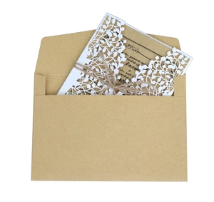 Detail of laser-cut gold leaf invitation set with kraft envelope and natural twine