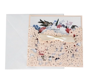 Détail de l'invitation en dentelle rose découpée au laser avec carte florale et ruban