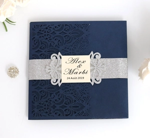 Elegant navy blue laser-cut wedding invitation with floral texture and silver glitter band
