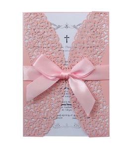 Detail of pink laser-cut floral wedding invitation with a silk ribbon bow and elegant text