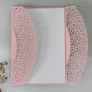 Macro detail of laser-cut floral invitation cover in pink glitter paper with white insert