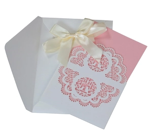 Laser-cut wedding invitation set with white lace cover and pink card with silk ribbon